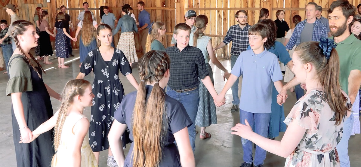 Young people and adults joining hands during a Barn Dance Revival dance
